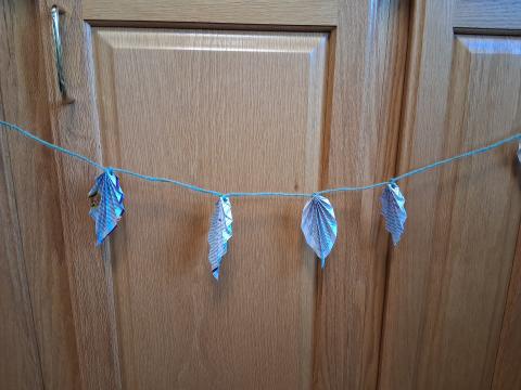 An images of paper leaves on a string. 