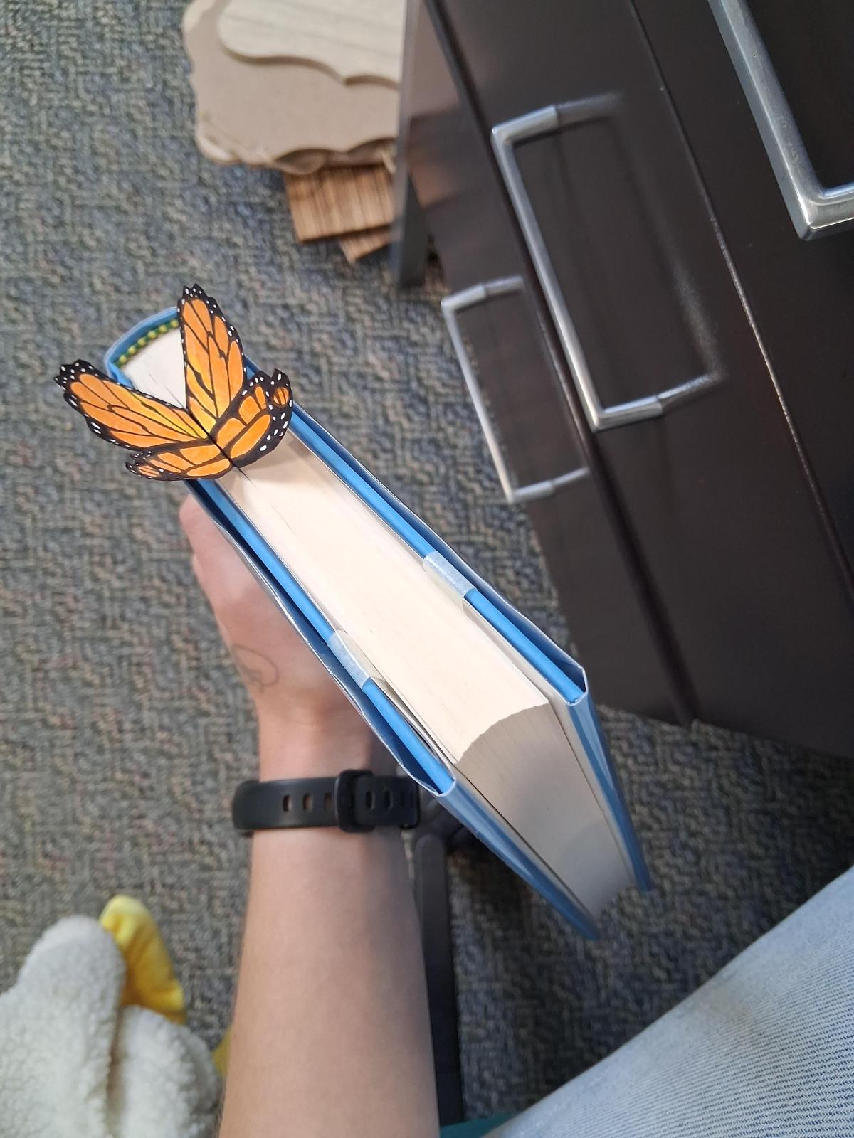A book with a butterfly bookmark