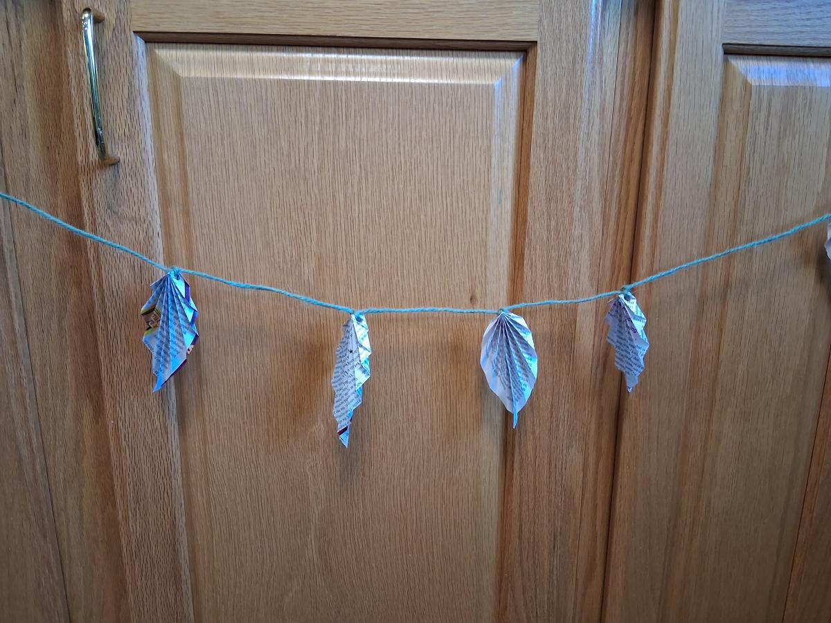 An images of paper leaves on a string. 