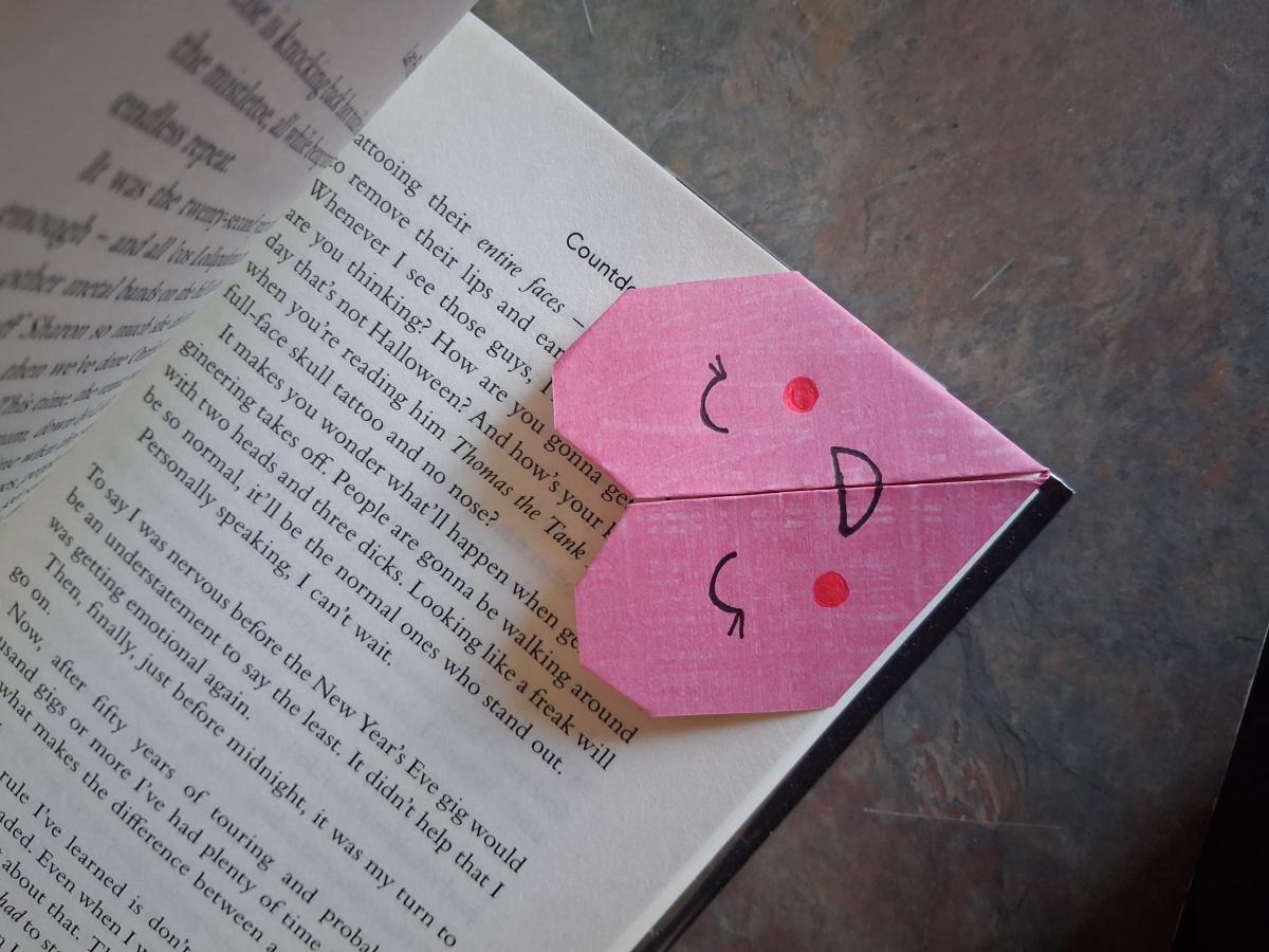 An image of a heart-shaped bookmark in a book. 